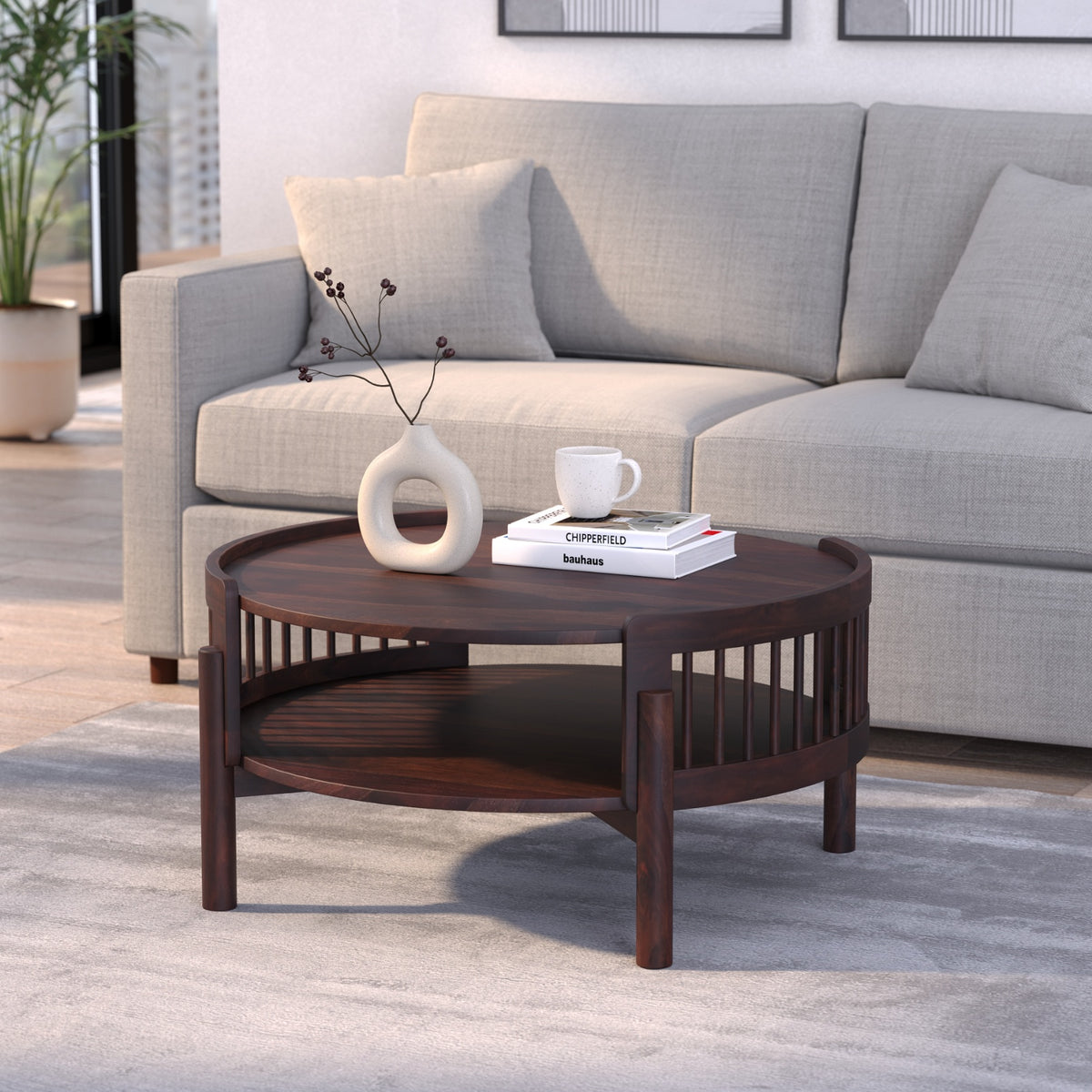 Wooden coffee table with decorative items in front of a gray sofa.