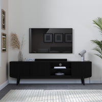 Modern living room with a black TV stand, television, and decorative elements.
