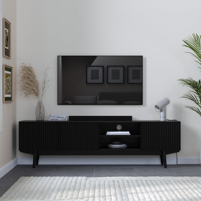 Modern living room with a black TV stand, television, and decorative elements.