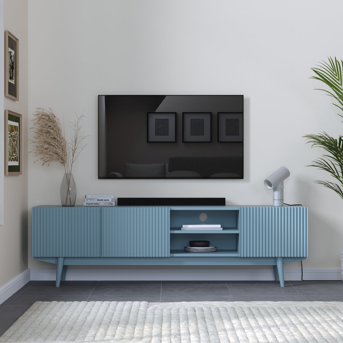 Teal TV stand with a television mounted on a white wall in a modern living room.
