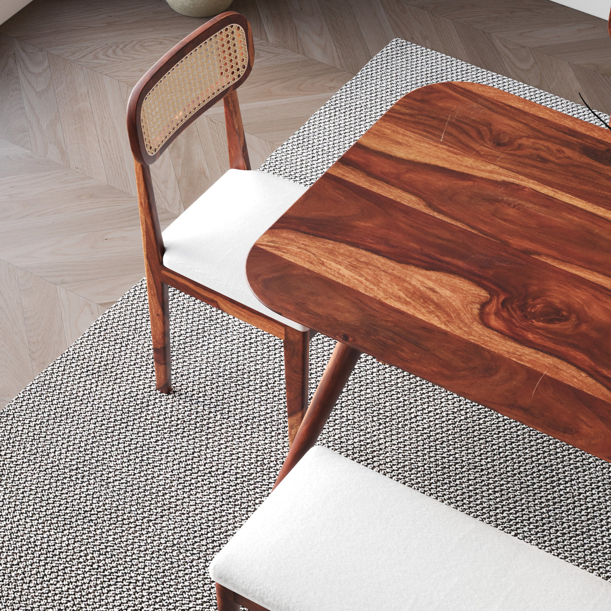 Wooden dining table with a chair on a textured floor