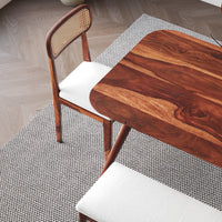 Wooden dining table with a chair on a textured floor