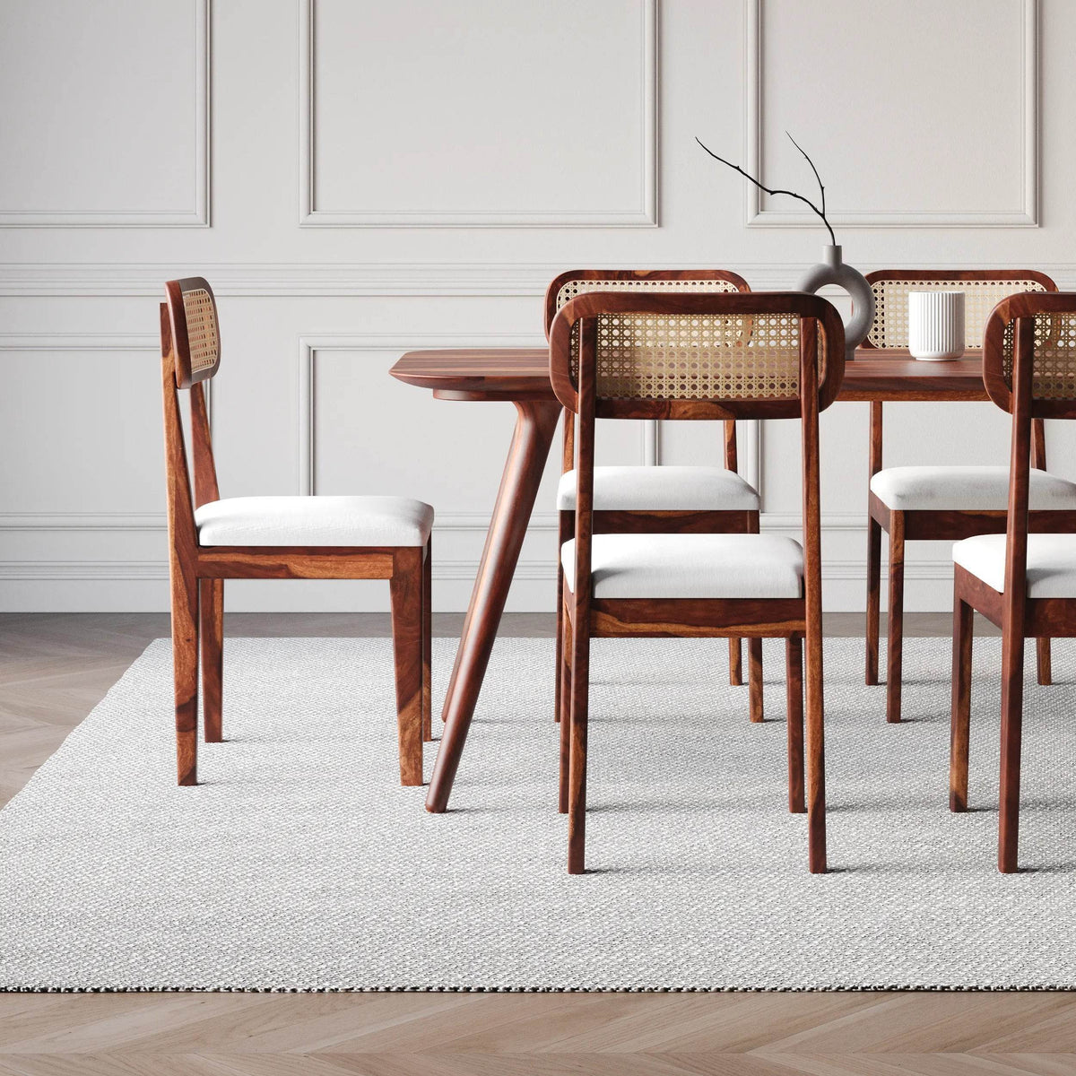 Dining table set with wooden chairs and white cushions side view