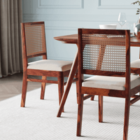 Dining table with wooden chairs featuring wicker backrests 