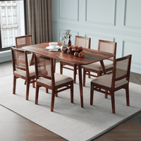 Wooden dining table with six chairs in a room with white walls and a window.