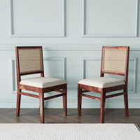 Two wooden chairs with woven backrests and white cushions 