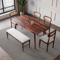 Dining room set with wooden table, chairs, and bench on a patterned rug.
