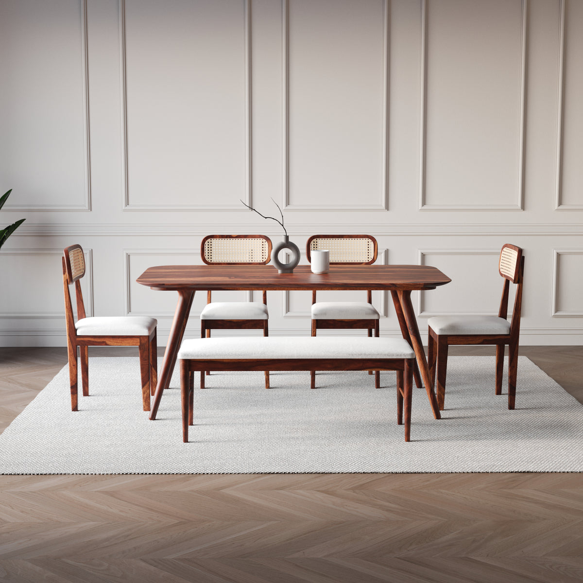 Dining room set with wooden table and chairs on a light rug.