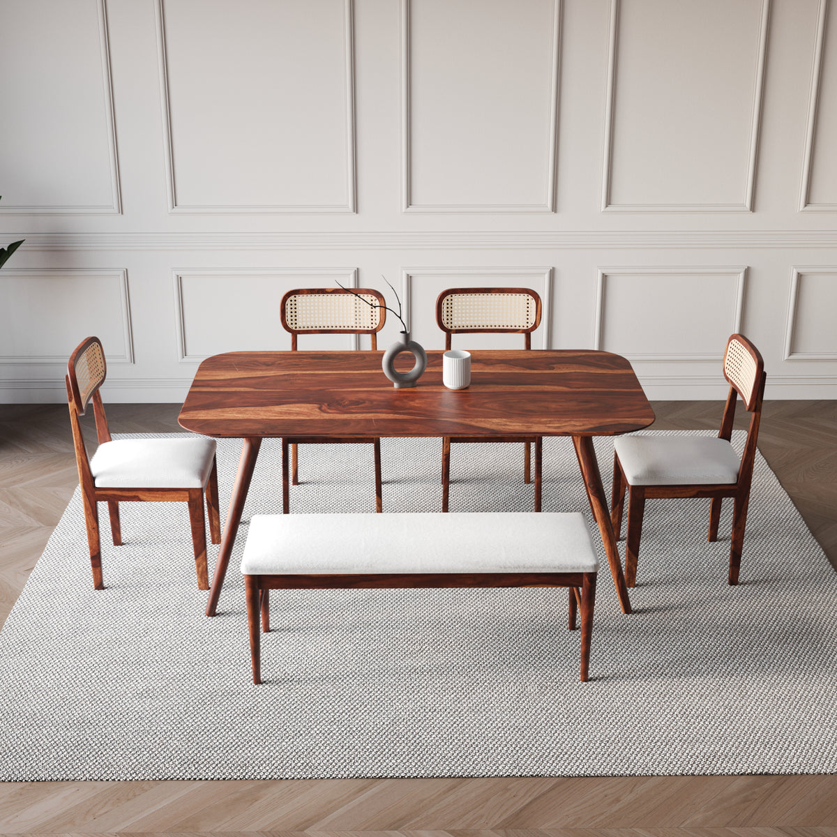 Dining room set with wooden table and chairs on a light gray rug.