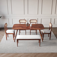 Dining room set with wooden table and chairs on a light gray rug.