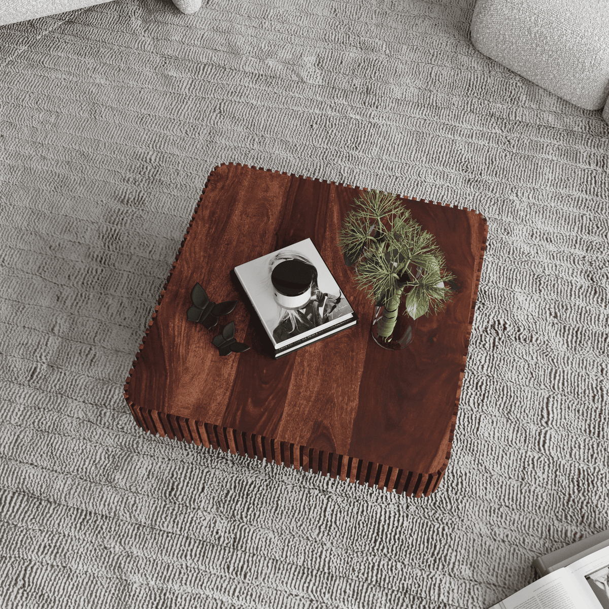 Wooden coffee table with decorative items on a gray carpet