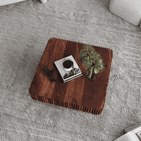Wooden coffee table with decorative items on a gray carpet