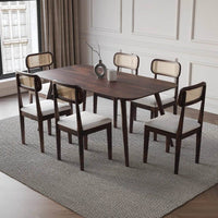 Dining room with a wooden table and six chairs on a gray rug.