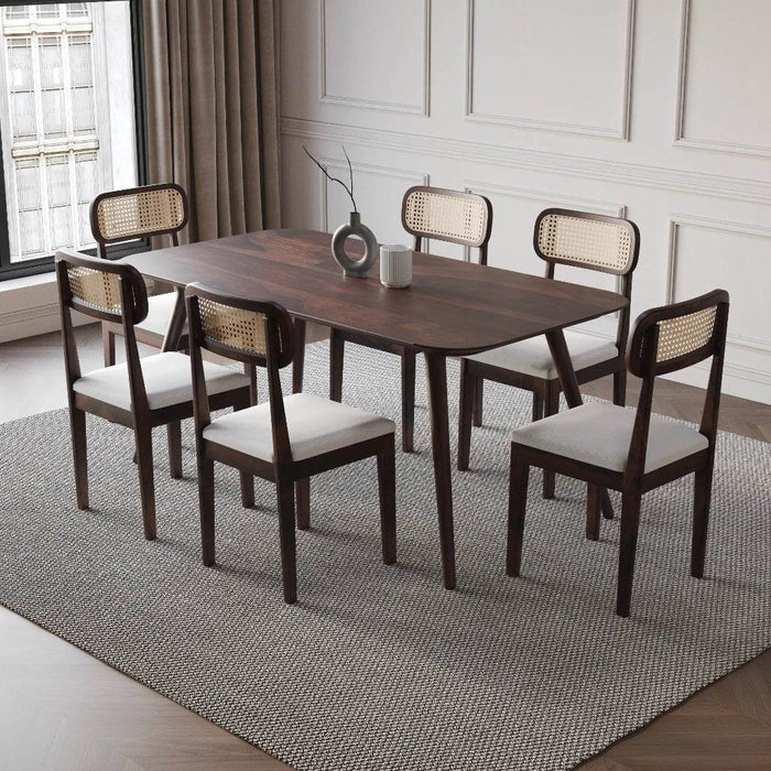 Dining room with a wooden table and six chairs on a gray rug.