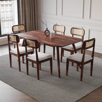 Dining room set with wooden table and chairs on a gray rug.