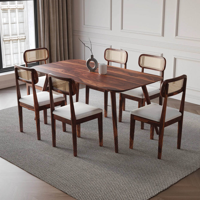 Dining room set with wooden table and chairs on a gray rug.