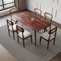 Dining table set with wooden chairs and white cushions in a room upper view