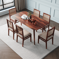 Dining table set with chairs in a room with light-colored walls and wooden flooring.